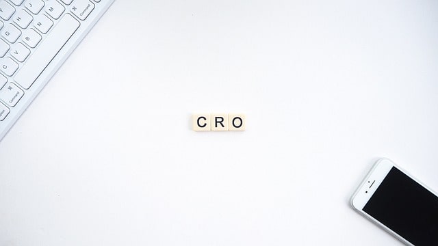 Website not generating leads, CRO. Image of desk with phone and keyboard and scabble tiles spelling CRO